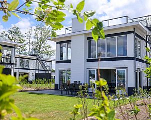 Villa Meerzicht 10 in Nijkerk, Veluwe is een luxe vakantiehuis met moderne architectuur en een ruim terras, omgeven door groene natuur.