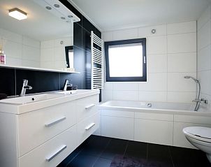 Luxe badkamer met bad en dubbele wastafel in Vakantiehuis Cube Magnifique 8, Nijkerk, Veluwe, Gelderland.