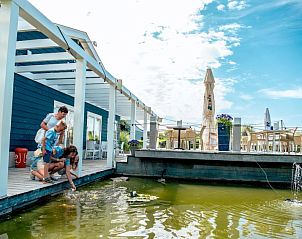 Gezin voert vissen bij terras van Vakantiehuis Cube Magnifique 8, Nijkerk, Veluwe, Gelderland.