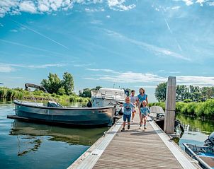 Gezin voert vissen bij de vijver van Vakantiehuis Villa Meerzicht 8, Nijkerk, Veluwe.