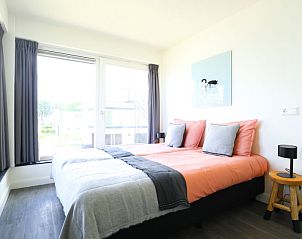 Slaapkamer met kleurrijk beddengoed in Vakantiehuis Villa Meerzicht 10, Nijkerk, Veluwe, Gelderland voor een frisse uitstraling.