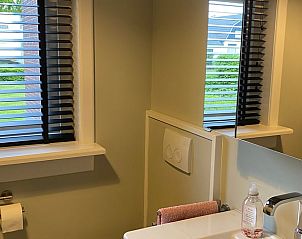 Frisse badkamer in Vakantiehuisje in Kootwijkerbroek, Veluwe, met modern sanitair en uitzicht op de tuin.