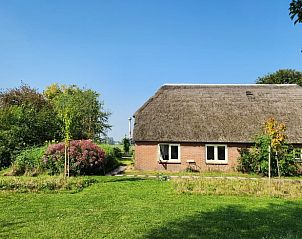 Zonnige tuin met traditionele architectuur bij Huisje in Klarenbeek, vakantieverblijf in Gelderland.