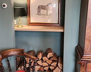 Kunstwerk en houtopslag in de woonkamer van Huisje in Klarenbeek, vakantiehuis op de Veluwe.