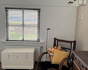 Gezellige zithoek in Huisje in Klarenbeek, Veluwe, met kleurrijke kussens en uitzicht op de natuur van Gelderland.