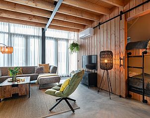 Moderne woonkamer in Vakantiehuis in Veessen, Veluwe, met houten interieur en veel lichtinval.