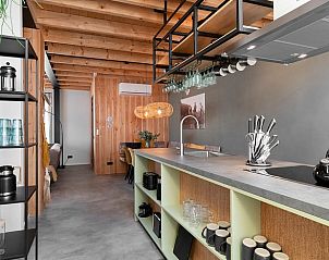 Moderne keuken in Huisje in Veessen, vakantiehuis op de Veluwe, met open planken en strakke inrichting.