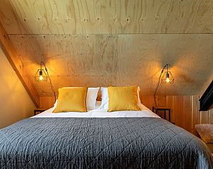 Knusse slaapkamer met houten afwerking in Huisje in Veessen, Veluwe, voor een ontspannen verblijf.