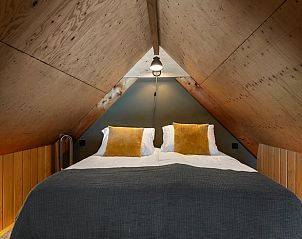 Gezellige zolderkamer in Huisje in Veessen, Veluwe, met houten interieur en comfortabele bedden.