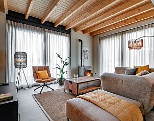 Gezellige woonkamer van Huisje in Veessen, Veluwe, Gelderland, met houtkachel en comfortabele zithoek.