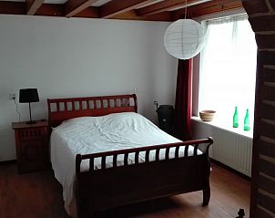 Knusse slaapkamer met houten bed in vakantiehuis Harkemas Hoeve, Den Ham Gr., Groningen