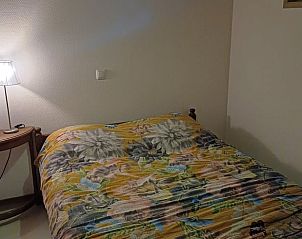 Sfeervolle slaapkamer in Vakantiehuisje in Uithuizermeeden, Noordoost Groningen, met comfortabel bed en lamp.