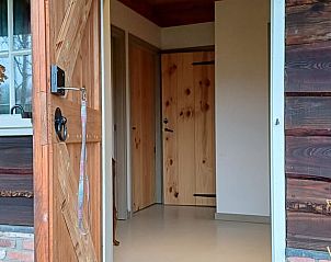 Gezellig entree bij Vakantiehuisje in Uithuizermeeden, Noordoost Groningen, met houten deur en landelijke charme.