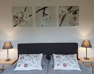 Slaapkamer in Chalet Wildemansheerd, vakantiehuis in Schildwolde, Groningen, met kunst aan de muur.