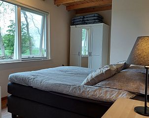 Frisse slaapkamer met uitzicht in Chalet Wildemansheerd, vakantiehuis in Schildwolde, Groningen.