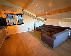 Gezellige woonkamer van Vakantiehuisje in Schildwolde, Noordoost Groningen, met comfortabele hoekbank en moderne inrichting.