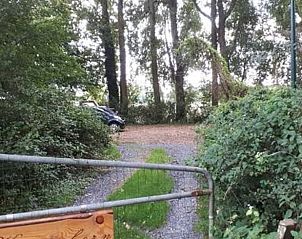 Ingang naar Vakantiehuisje in Uithuizen, omgeven door weelderige natuur in Groningen.