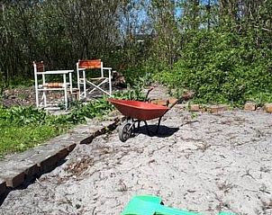 Zandtuin met kruiwagen bij Vakantiehuisje in Uithuizen, Noordoost Groningen.