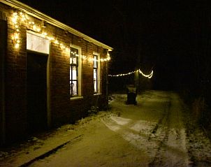 Verlichte buitenzijde van Vakantiehuisje in Uithuizen, Groningen in winterse sfeer.