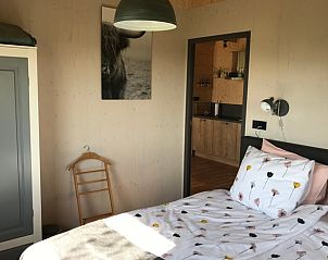 Gezellige slaapkamer in Vakantiehuis in Overschild, Groningen met houten interieur.