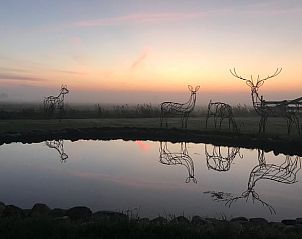 Magische zonsopgang bij Vakantiehuis in Overschild met kunst en vijver, Groningen.