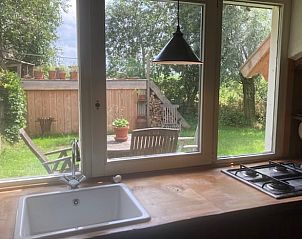 Keuken met uitzicht op tuin in Vakantiehuis in Overschild, Noordoost Groningen.
