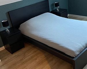 Gezellige slaapkamer met donker houten bed in Vakantiehuisje in Leermens, Noordoost Groningen.
