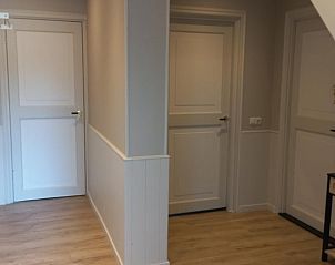 Moderne hal in Vakantiehuisje in Leermens, Noordoost Groningen, met stijlvolle deuren en houten vloeren.