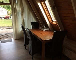 Eethoek in Robbenoort 29, Lauwersoog, Groningen met houten tafel en stoelen, ideaal voor gezellige maaltijden tijdens je vakantie.