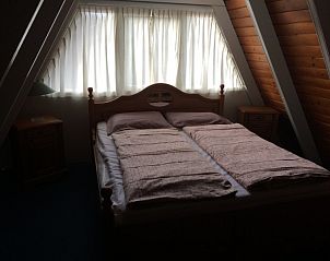 Slaapkamer met tweepersoonsbed in Robbenoort 29, Lauwersoog, Groningen, biedt rust en comfort voor een goede nachtrust.