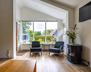 Gemtliches Wohnzimmer des Ferienhauses GR032 in Lauwersoog, Groningen mit Blick in den Garten.