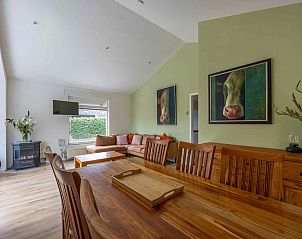 Sonnige Terrasse des Ferienhauses GR032 in Lauwersoog, umgeben von blhenden Pflanzen.