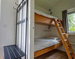 Vorderansicht des Ferienhauses GR032 in Lauwersoog, mit Auffahrt und grnem Garten.