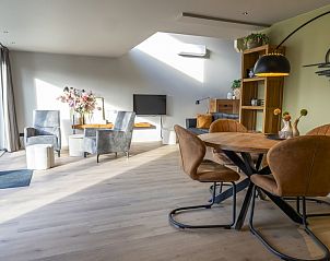 Moderne woonkamer van Robbenoort 106, 't Puttertje in Lauwersoog, Groningen met veel lichtinval.