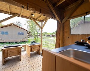 Safaritent 8 in Vierhuizen, Groningen biedt een charmant terras met houten veranda midden in de natuur voor een unieke glamping ervaring.