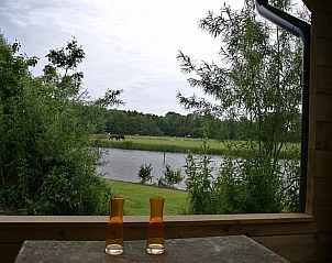 Geniet van het serene uitzicht op de natuur vanaf de veranda van Huisje in Zoutkamp, een vakantiehuis in Noordwest Groningen.