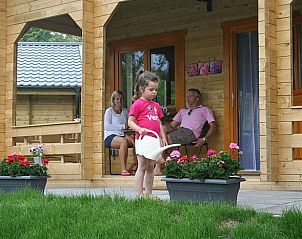 Gezellige veranda van Huisje in Zoutkamp, vakantiehuis in Noordwest Groningen, met familie die ontspant te midden van de natuur.