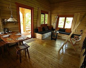 Gezellige woonkamer van Huisje in Zoutkamp, vakantiehuis in Noordwest Groningen, met houten interieur en uitzicht op de groene omgeving.