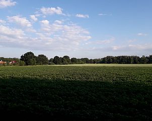 Uitzicht op groene velden vanuit Vakantiehuis in Ter Apel, serene omgeving in Groningen.
