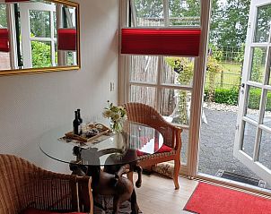 Gezellige eetruimte met uitzicht op de tuin in Vakantiehuisje in Vriescheloo, Groningen.