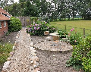 Gezellige tuin met zitplek bij Vakantiehuisje in Vriescheloo, ideaal voor ontspanning.