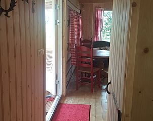 Houten gang in vakantiehuisje in Vriescheloo, leidt naar knusse leefruimte, ideaal voor een rustige vakantie in Groningen.