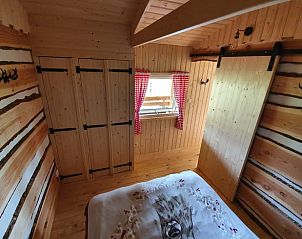 Slaapkamer in vakantiehuisje in Vriescheloo met houten interieur, biedt rustieke charme in Zuidoost Groningen.