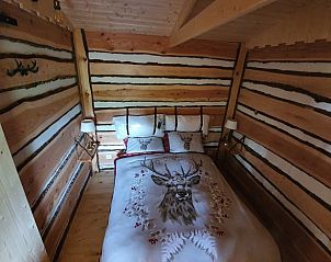 Comfortabele slaapkamer in vakantiehuisje in Vriescheloo met hertenbeddengoed, perfect voor natuurliefhebbers in Groningen.