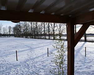 Winterlandschap gezien vanaf het terras van vakantiehuisje in Vriescheloo, ideaal voor een rustige vakantie in Groningen.