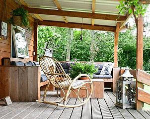Gezellig terras met schommelstoel bij vakantiehuisje in Vriescheloo, ideaal voor ontspannen momenten in Groningen.