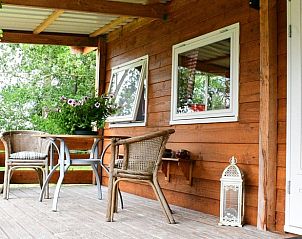 Charmant zitgedeelte op veranda van vakantiehuisje in Vriescheloo, perfect voor buitenontbijt in Zuidoost Groningen.