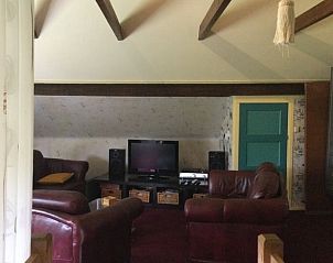 Comfortabele woonkamer in Huisje in Vriescheloo, vakantieaccommodatie in Zuidoost Groningen, met lederen banken en tv.