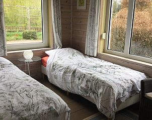 Sfeervolle slaapkamer in Huisje in Vriescheloo, vakantieaccommodatie in Zuidoost Groningen, met uitzicht op de tuin.