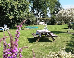 Picknicktafel in de tuin van Vakantiehuis in Vriescheloo, omringd door bloemen in Groningen.